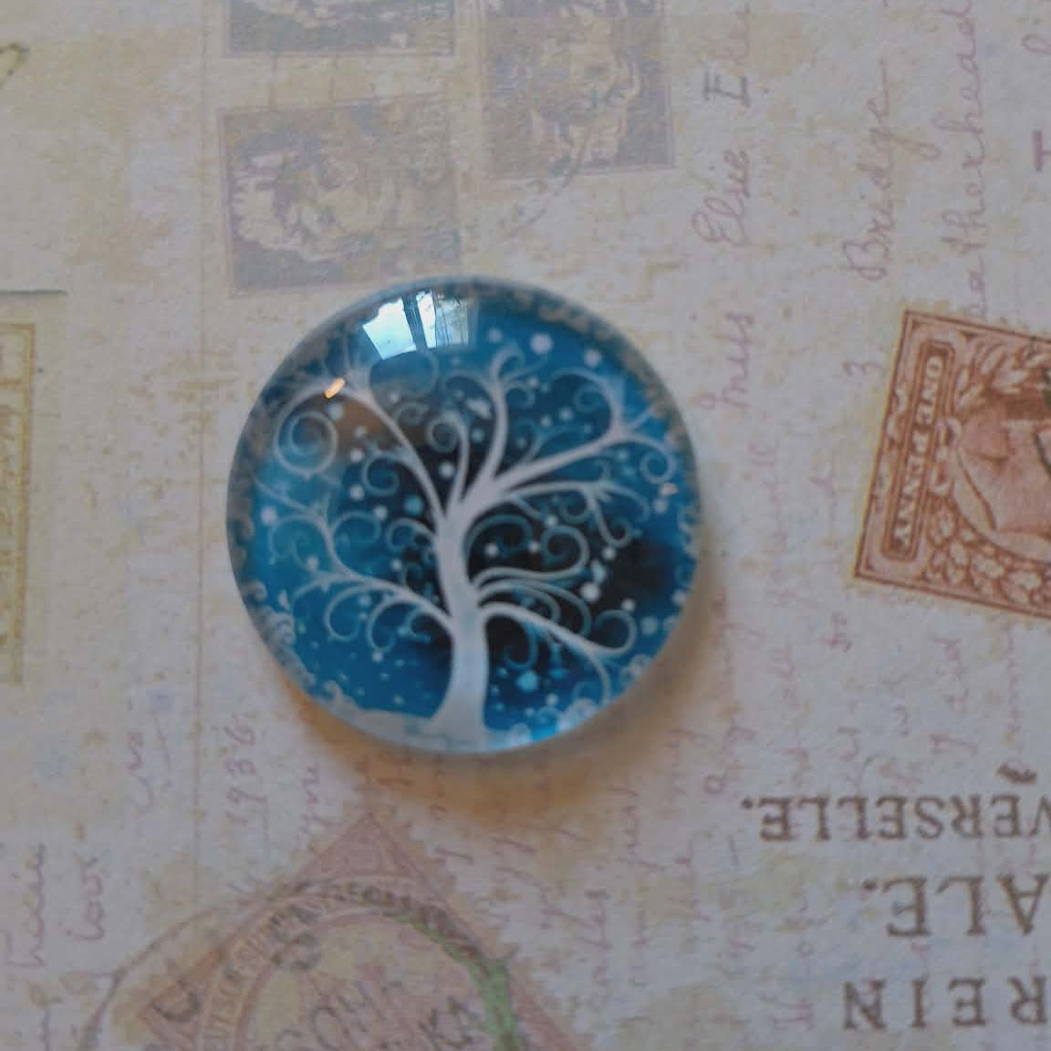 Round blue and white decorative item on a textured surface with vintage stamps and text.
