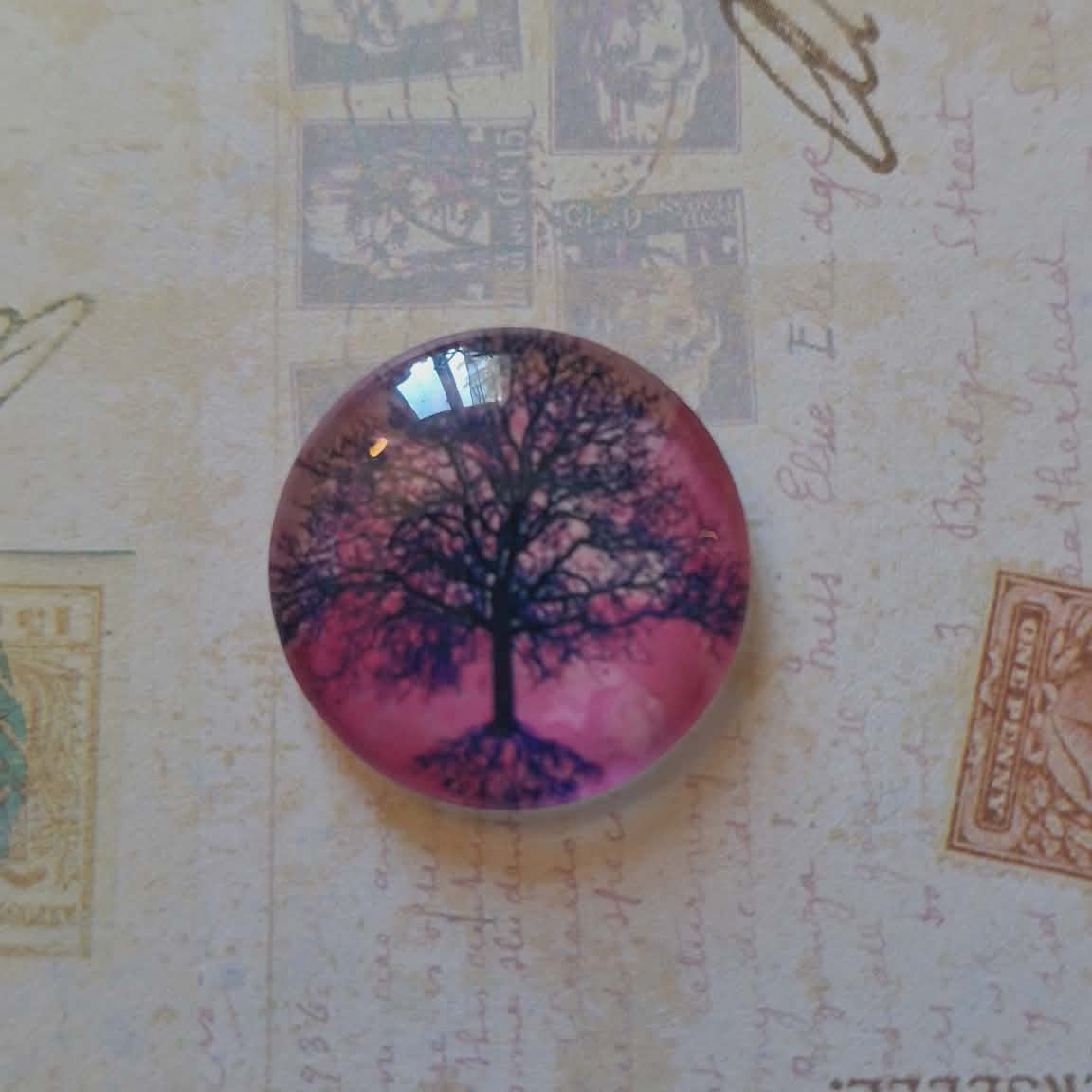 Round decorative item with tree design on a textured background