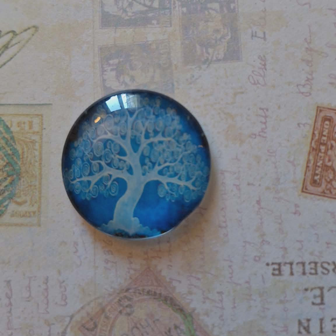 Round blue and white tree design on a textured background with stamps
