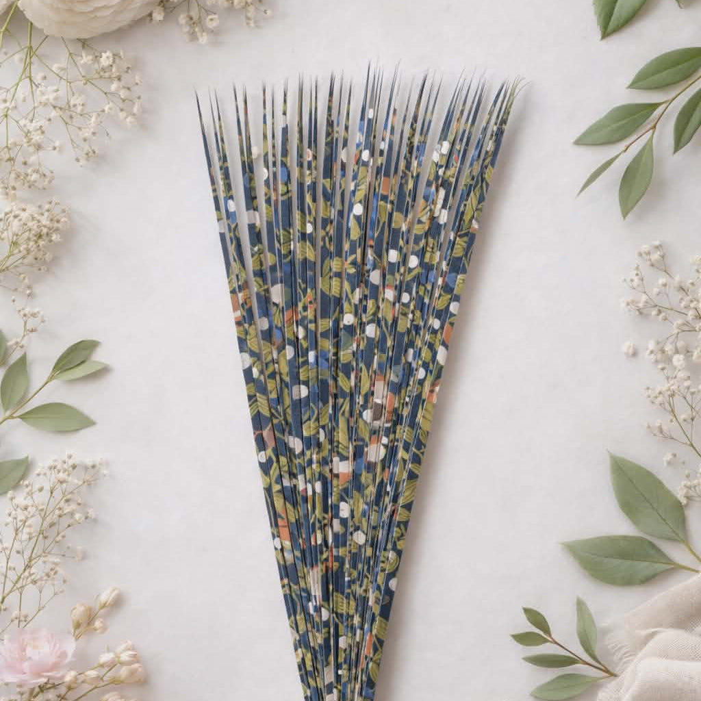 Decorative precut paper strips with floral pattern on a light background with flowers and scissors