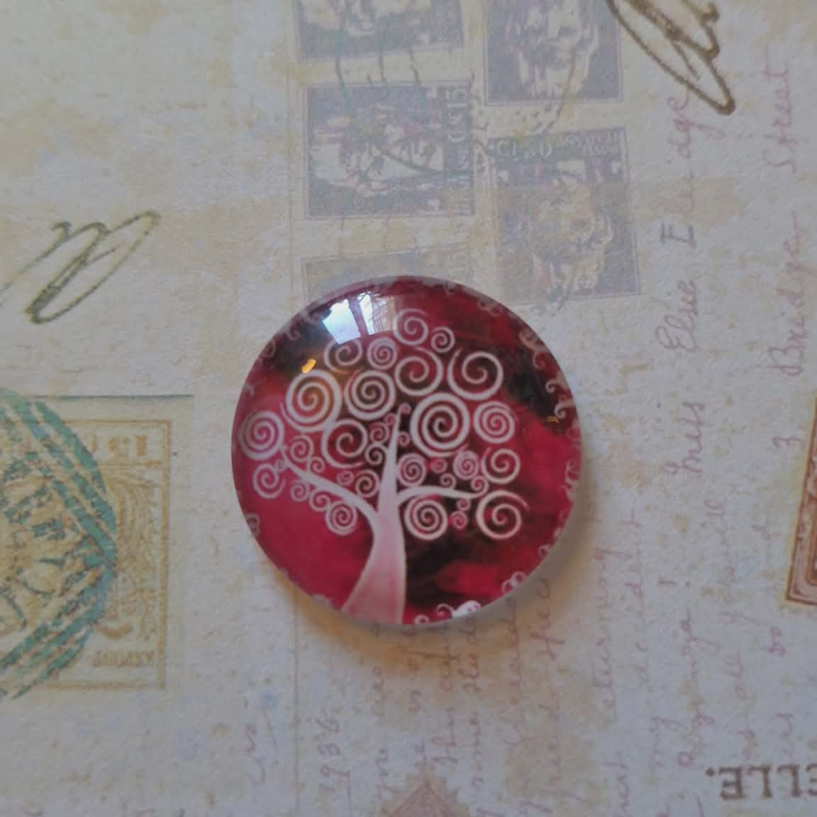 Round red and white decorative item on a textured surface with vintage stamps and text.
