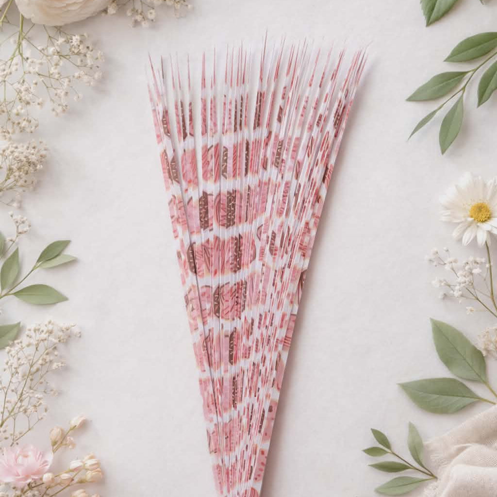Decorative pink pre-cut paper strips surrounded by flowers and greenery on a light background