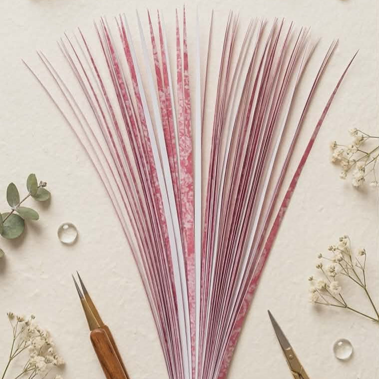Decorative bundle of  precut paper strips with a pen and scissors on a light background