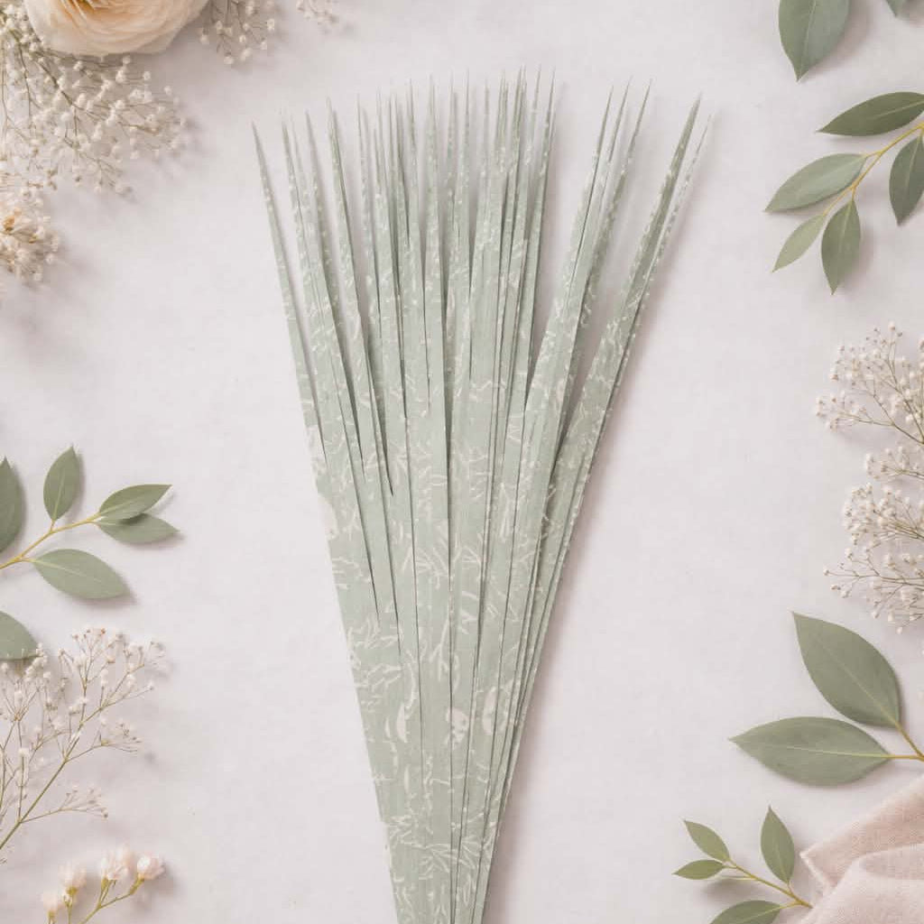Decorative greenery  precut paper strips with flowers, leaves, and scissors on a light background