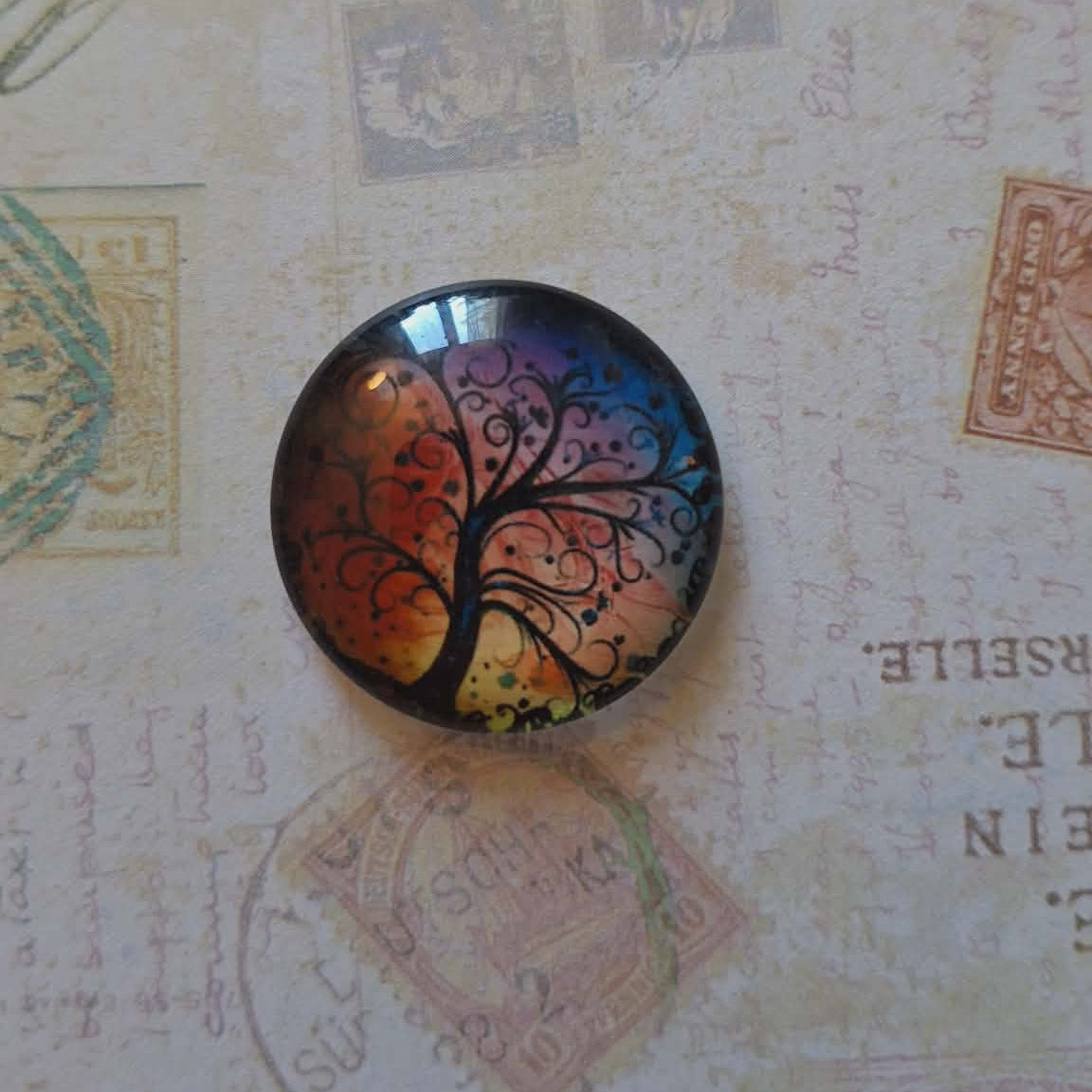 Round decorative item with a tree design on a textured background