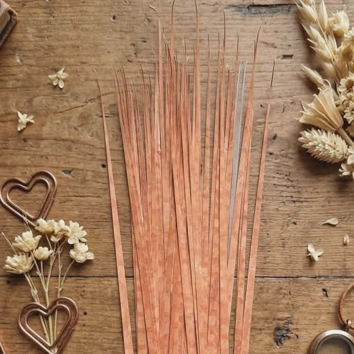 precut paper strips on a wooden surface with decorative elements.