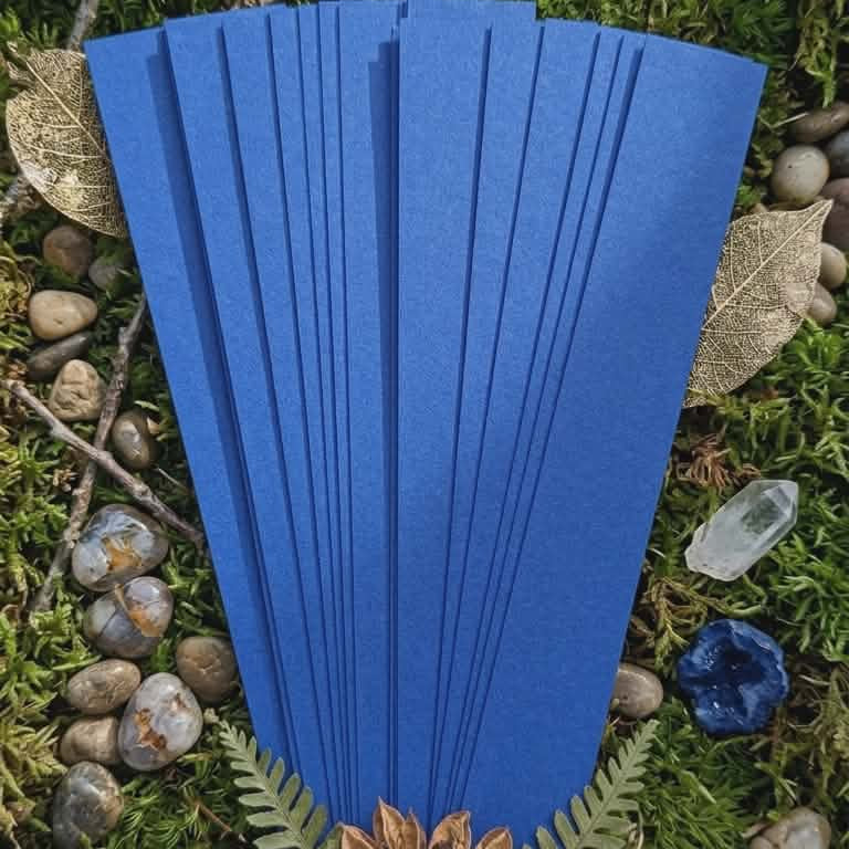 Blue pre-cut paper strips on a natural background with stones and leaves