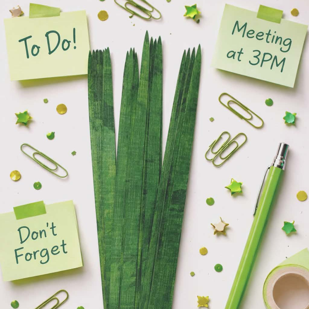 Green paper bead rolling strips for DIY jewelry making displayed in styled flat lay with craft supplies