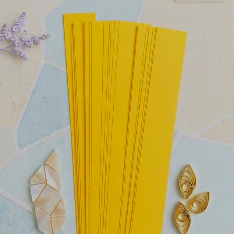 Yellow folded paper on a decorative background with geometric shapes and flowers.