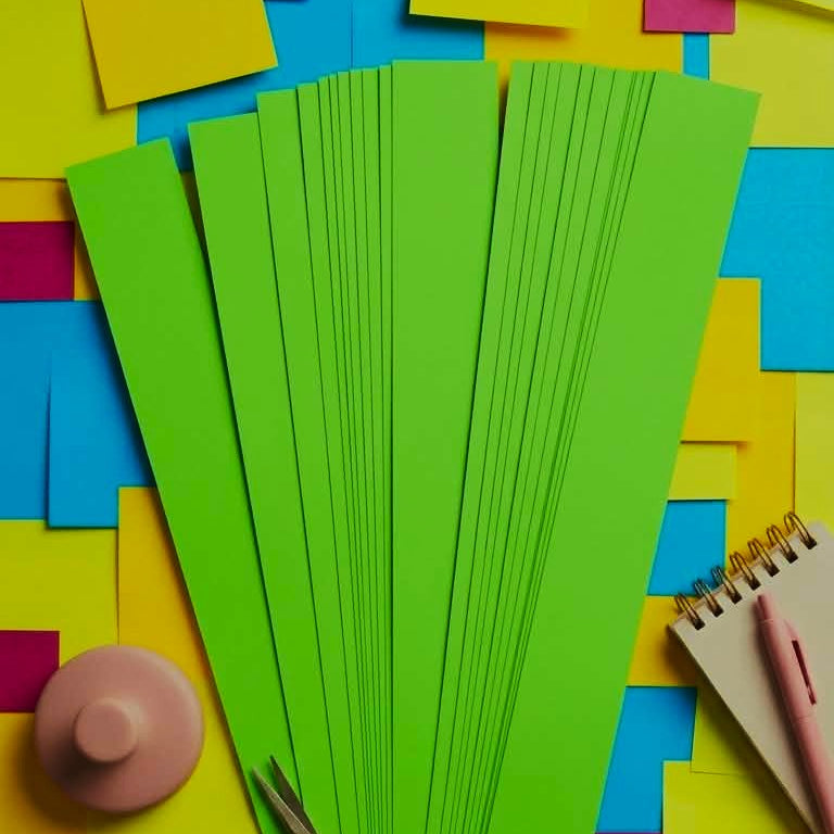 Green paper strips with scissors on a colorful background
