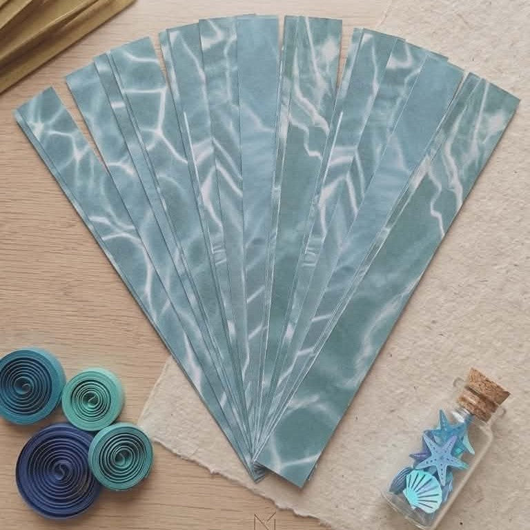 Marble-patterned paper sheets on a wooden surface with decorative items.