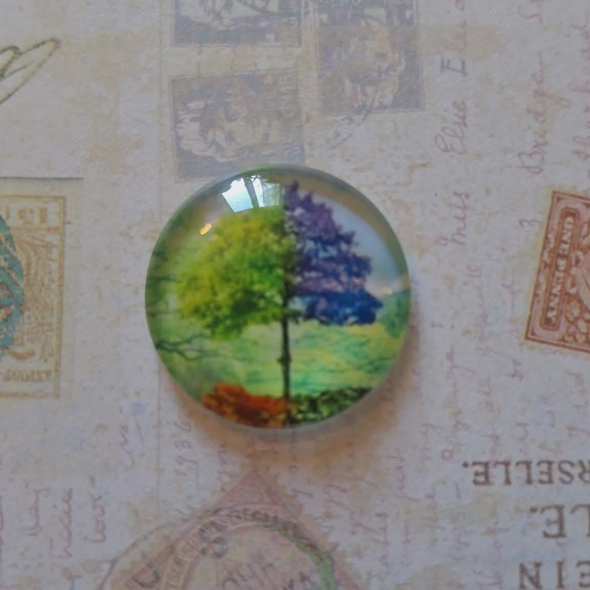 Round stained glass piece with floral design on a textured paper background